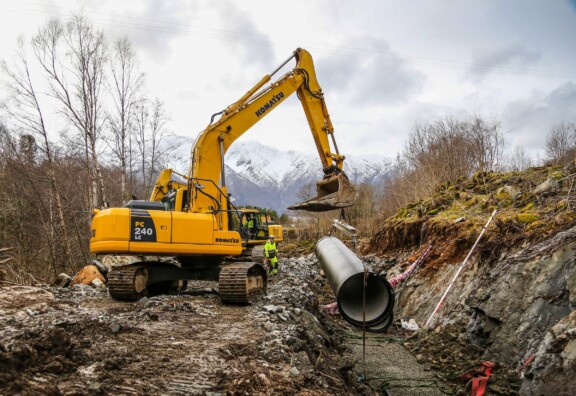 Gul gravemaskin og rørlegging