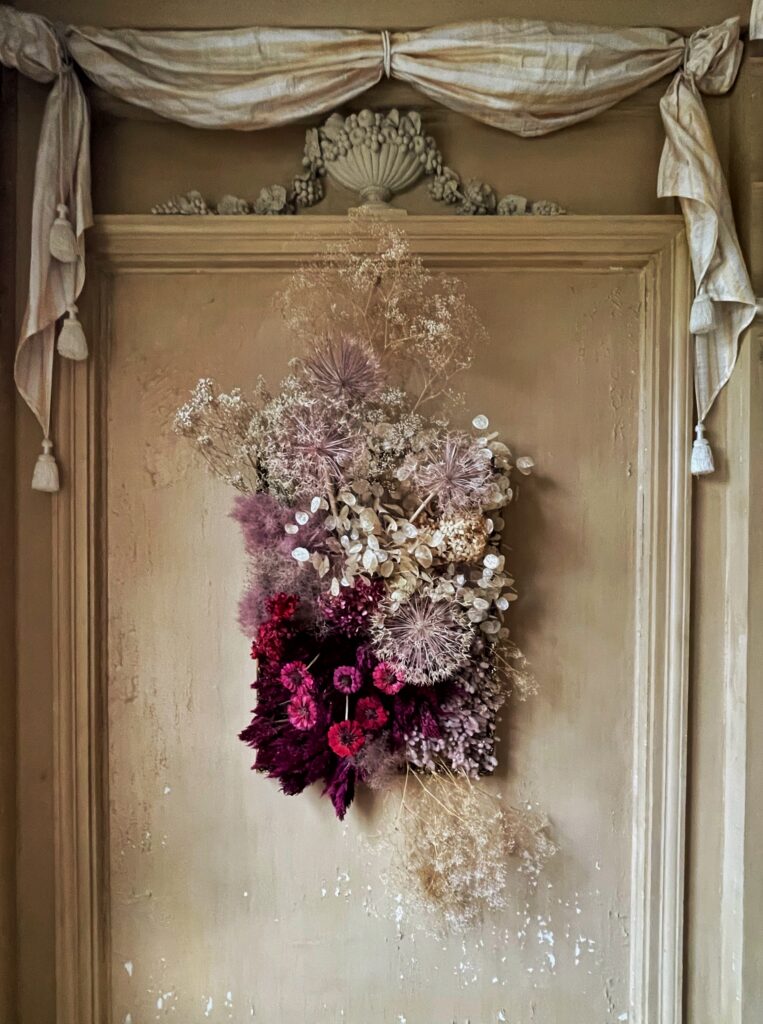 Foto av tørka blomster satt sammen til et bilde på veggen i Gunnebo slott