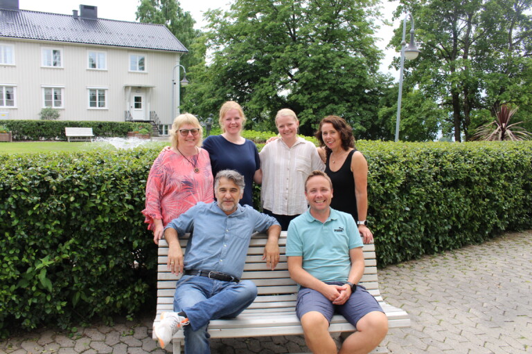seks personer avbildet ute i hageanlegg på Vea