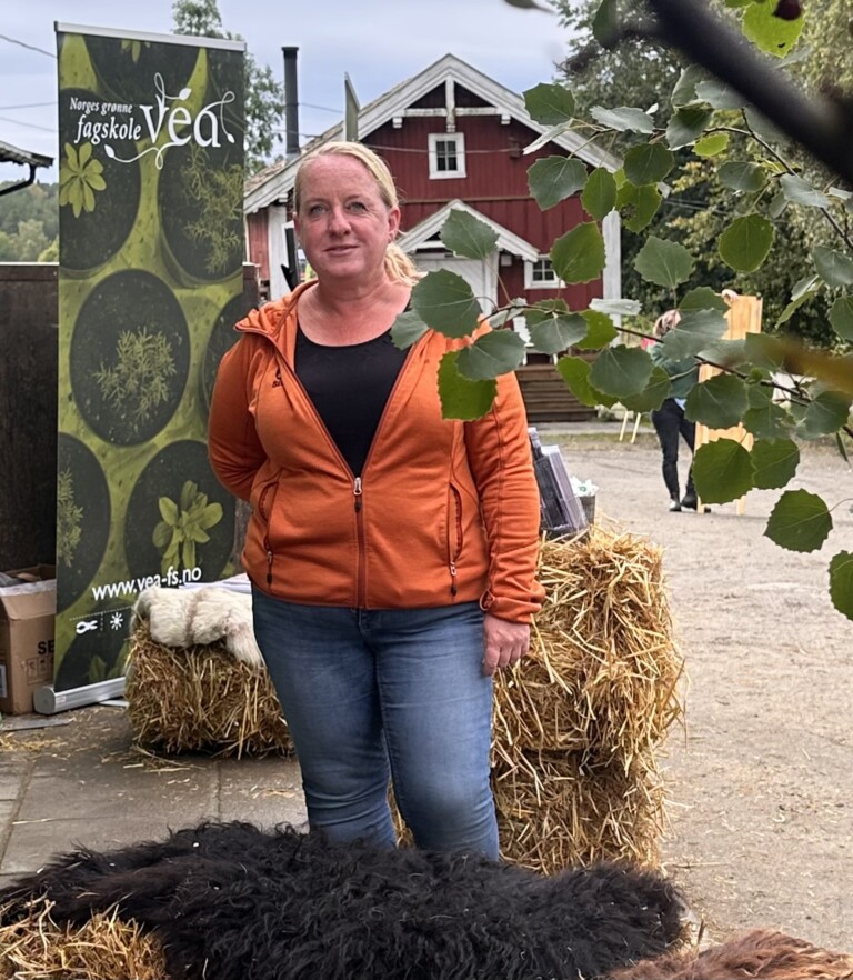 Dame med lyst hår og oransje genser