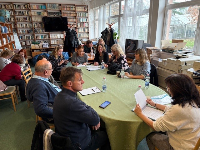 Personer som sitter rundt et bord med grønn duk