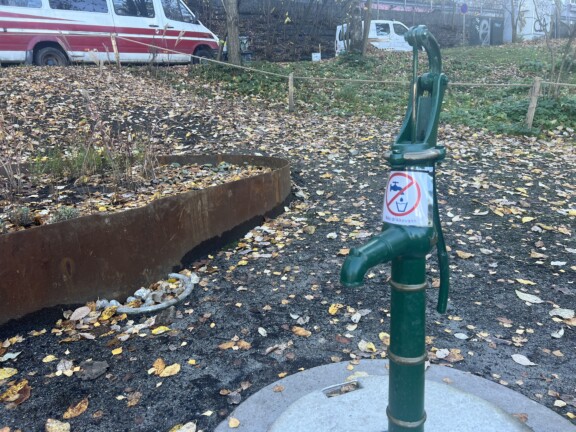 En grønn pumpekran som står ute i en park