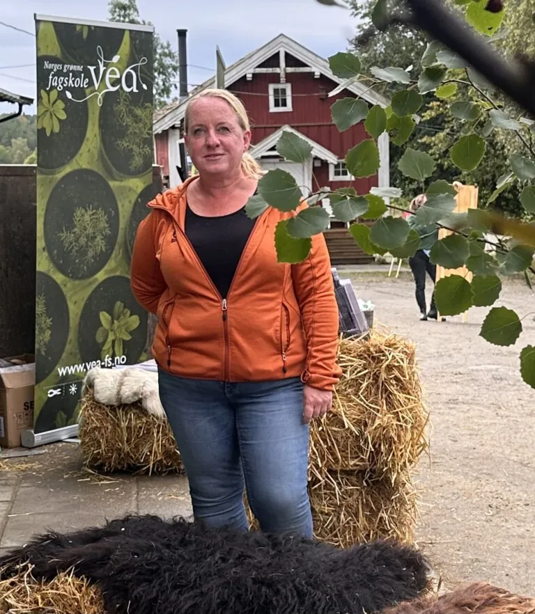 Dame med lyst hår og oransje genser