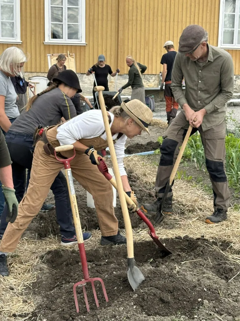 Fagskolestudenter som graver i hagen