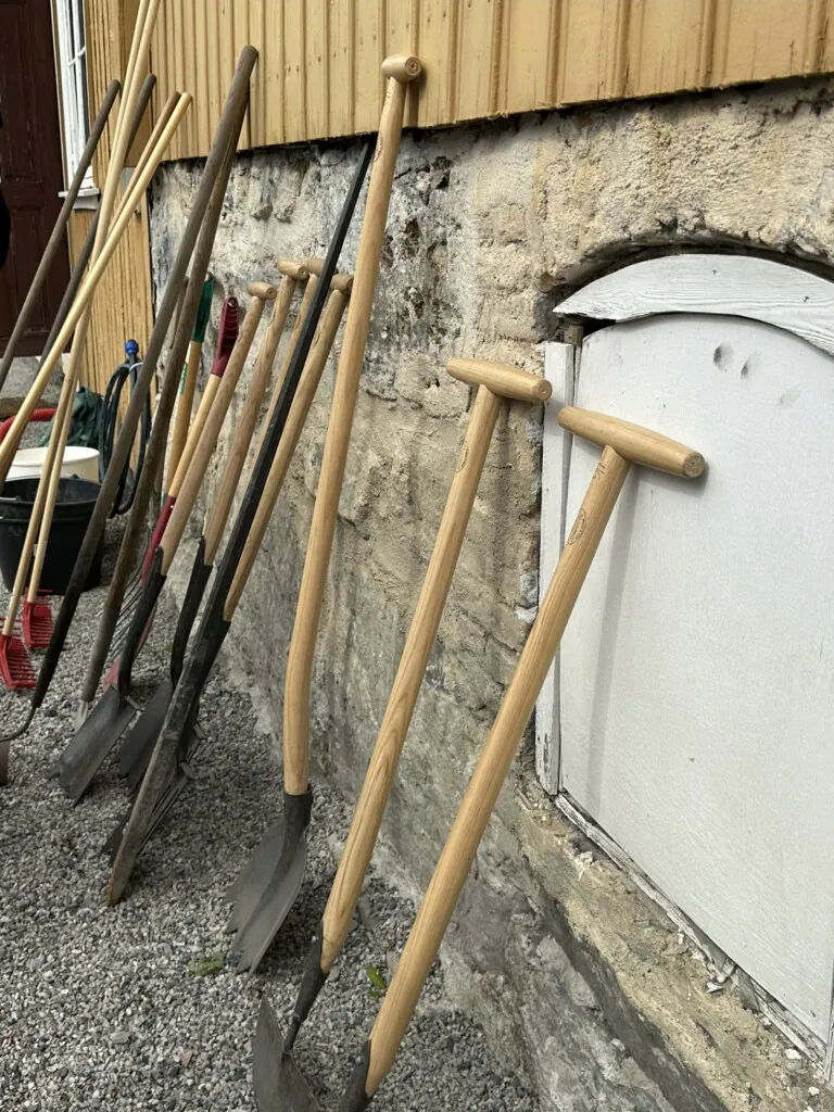 Hageredskaper som er stilt opp langs en vegg