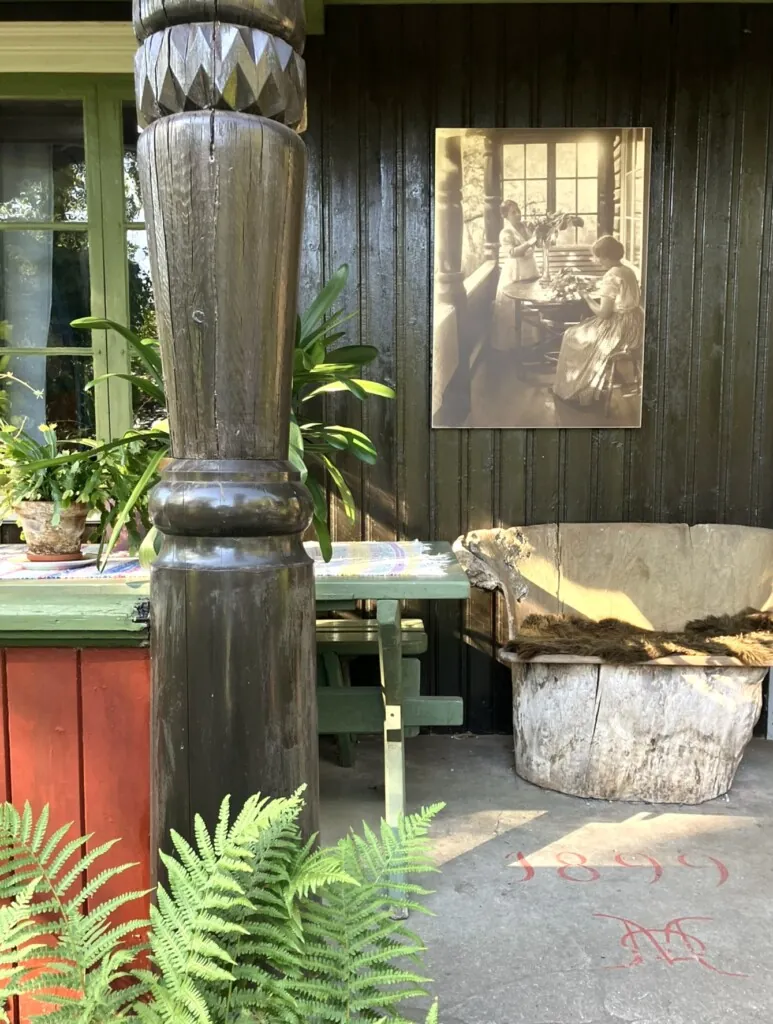 Brunmalt søyle i tre utenfor gammelt hus