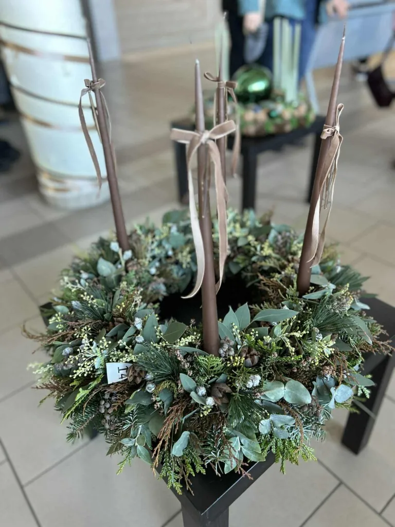 Adventskrans laget av vintergrønt med grå/lilla lys