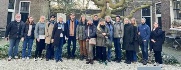 En gruppe studenter samlet foran et gammelt tre