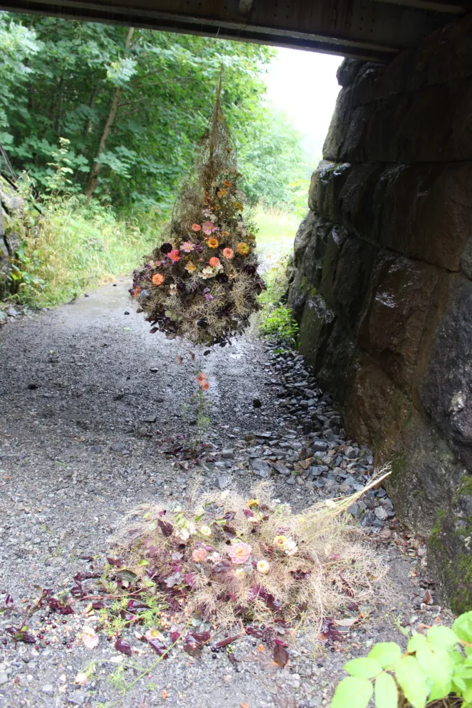 Botanisk blomsterarbeid som henger under en jernbanebro