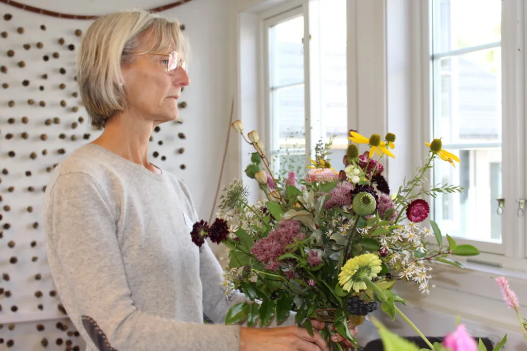 Dame som lager blomsterbukett