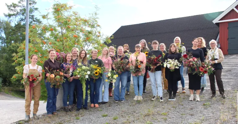 19 damer med blomsterbukett i hånda, samlet ute på Norges grønne fagskole -Vea