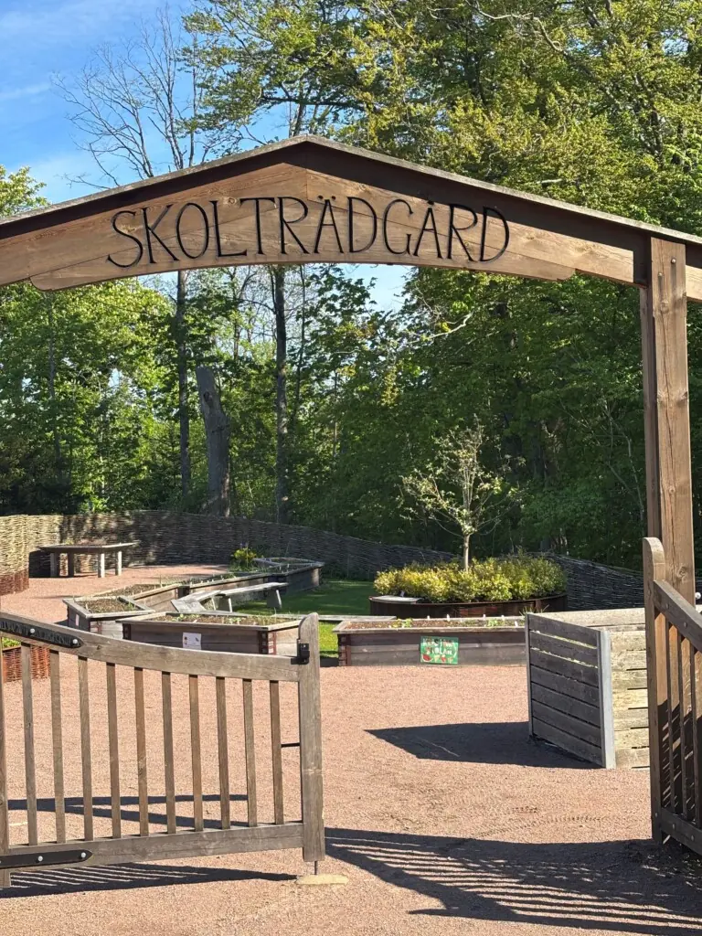 Portal i tre som viser vei til skolehage