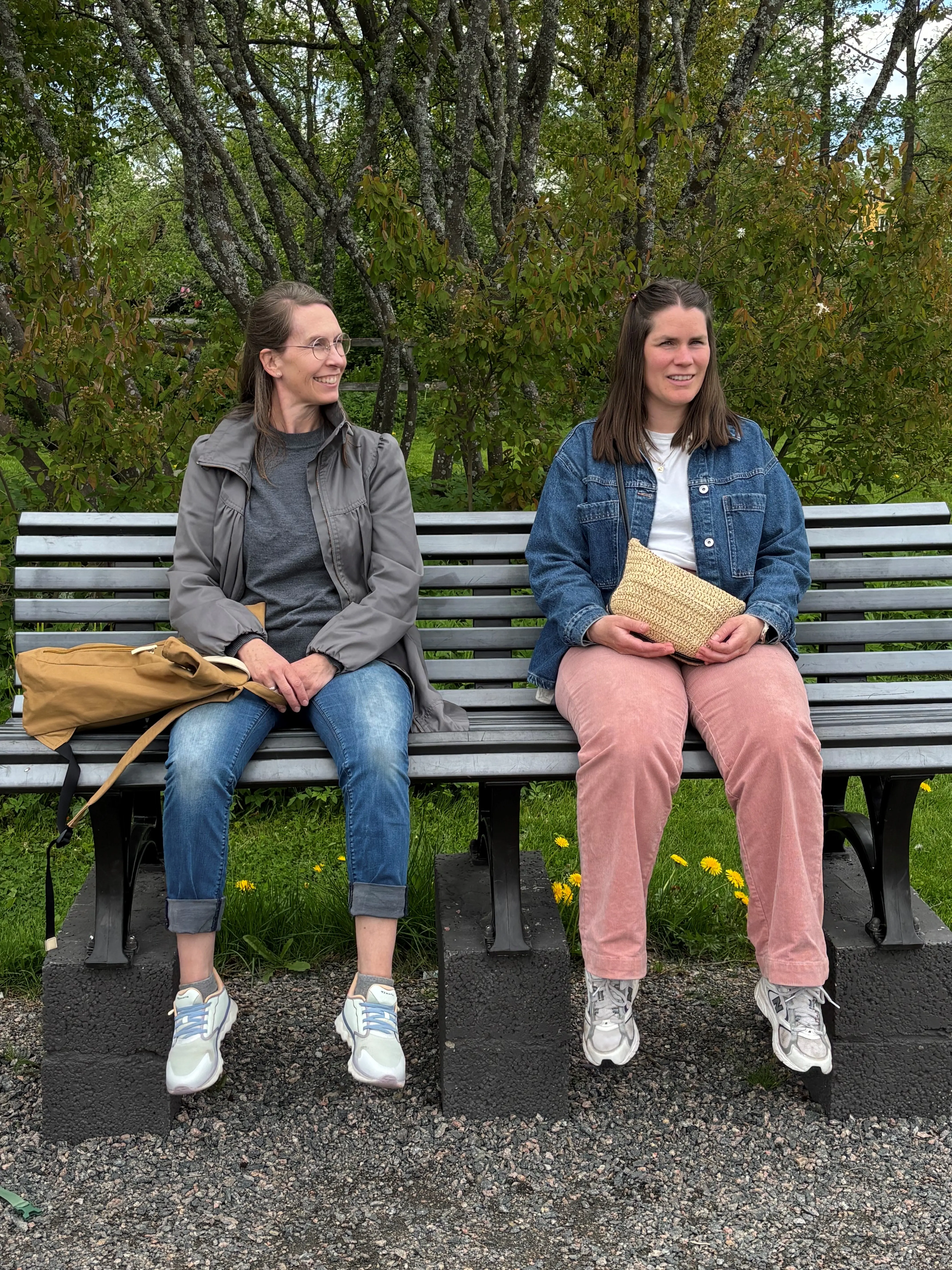 To damer som sitter på en dinglebenk